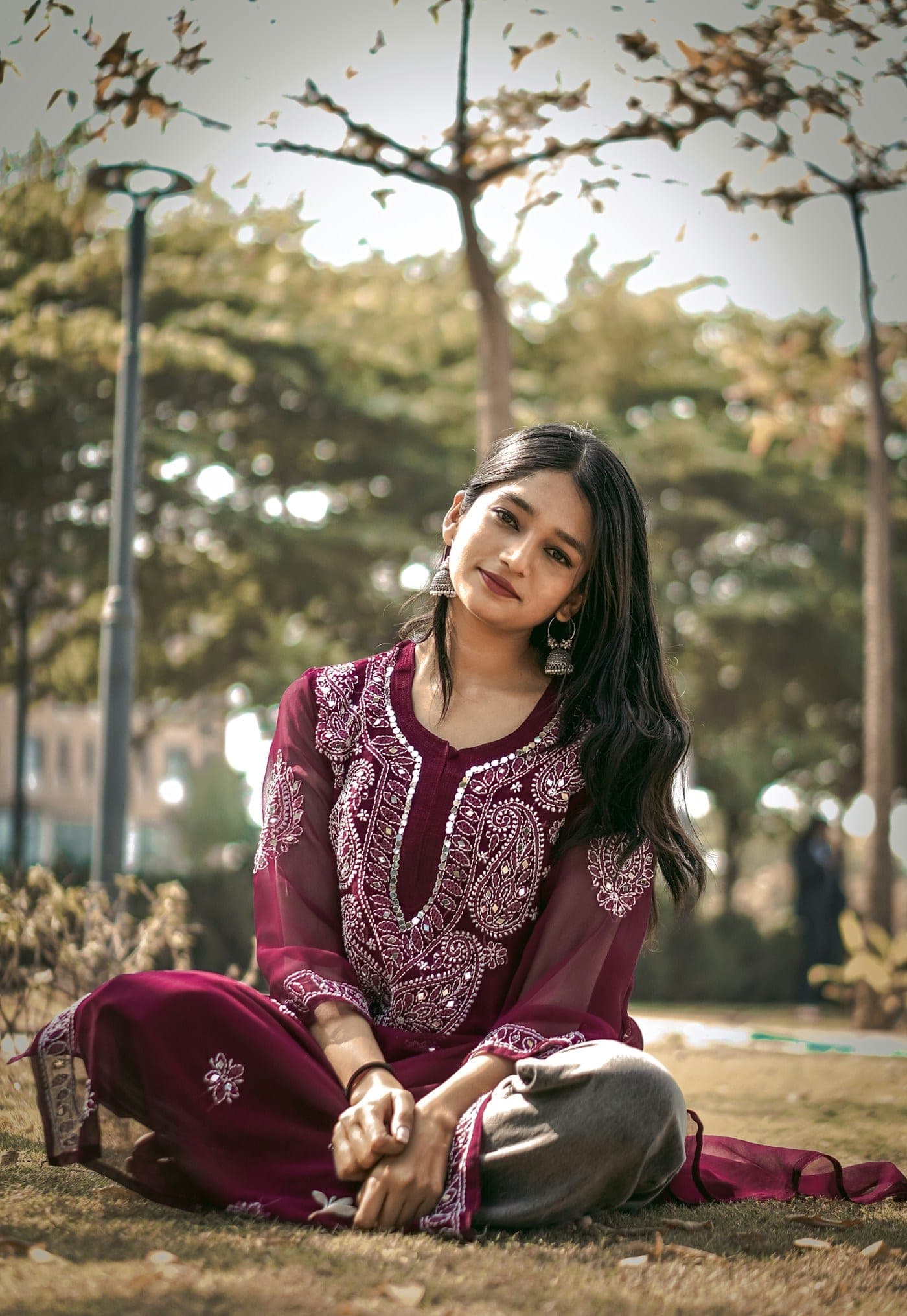 Woman in a wine embroidered kurta seated outdoors