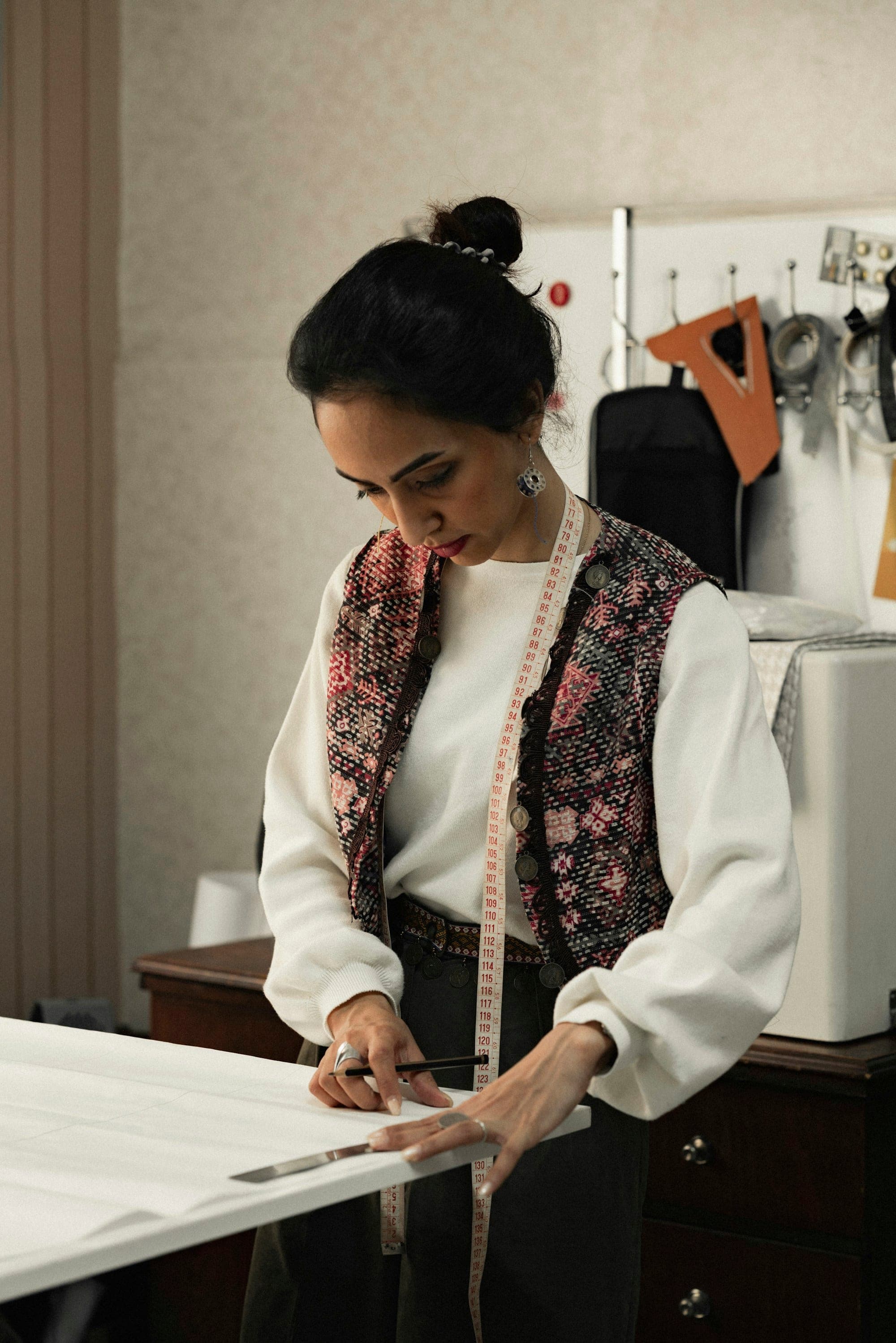 Designer drafting a pattern at a cutting table in the studio