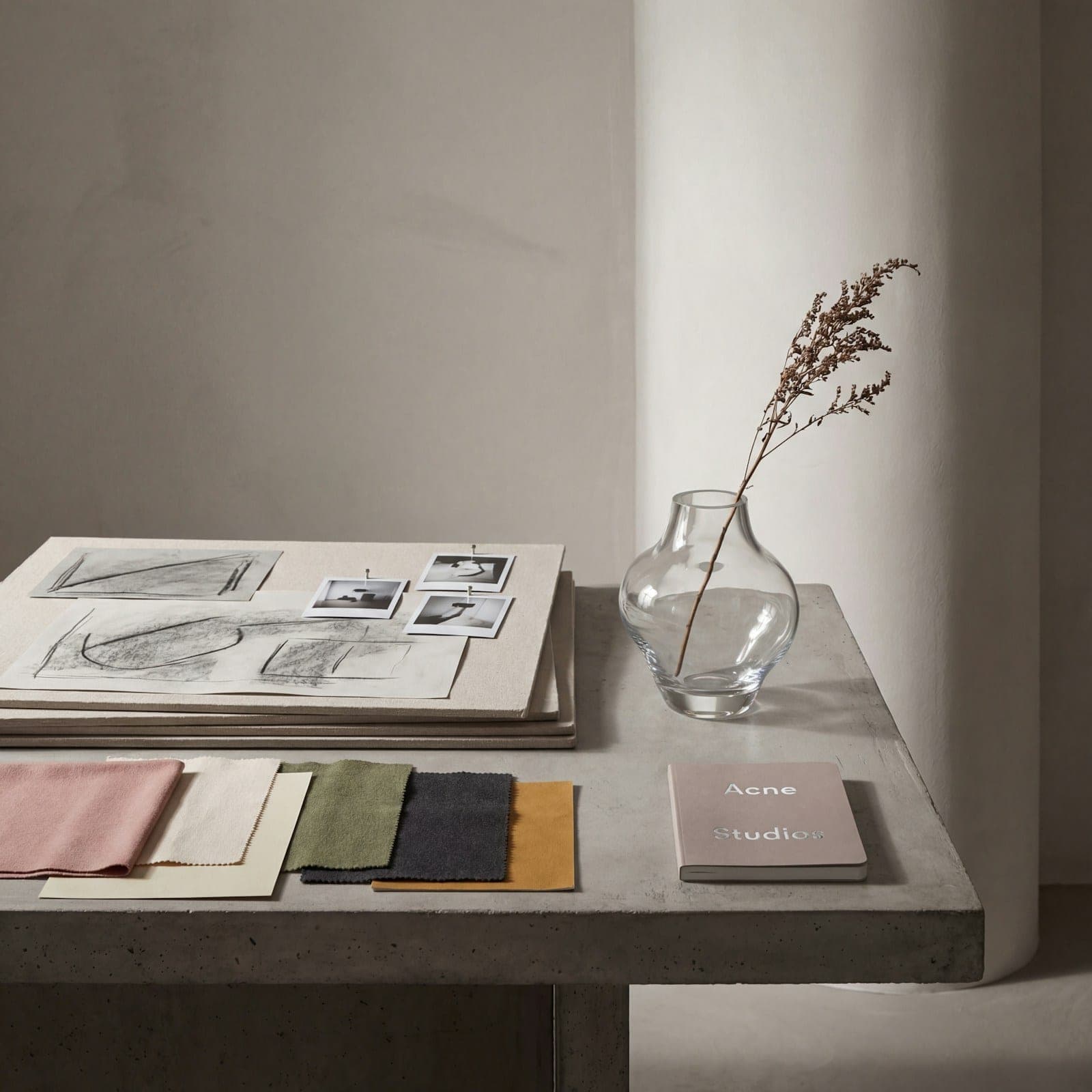 Fabric swatches and sketches laid out on a stone table