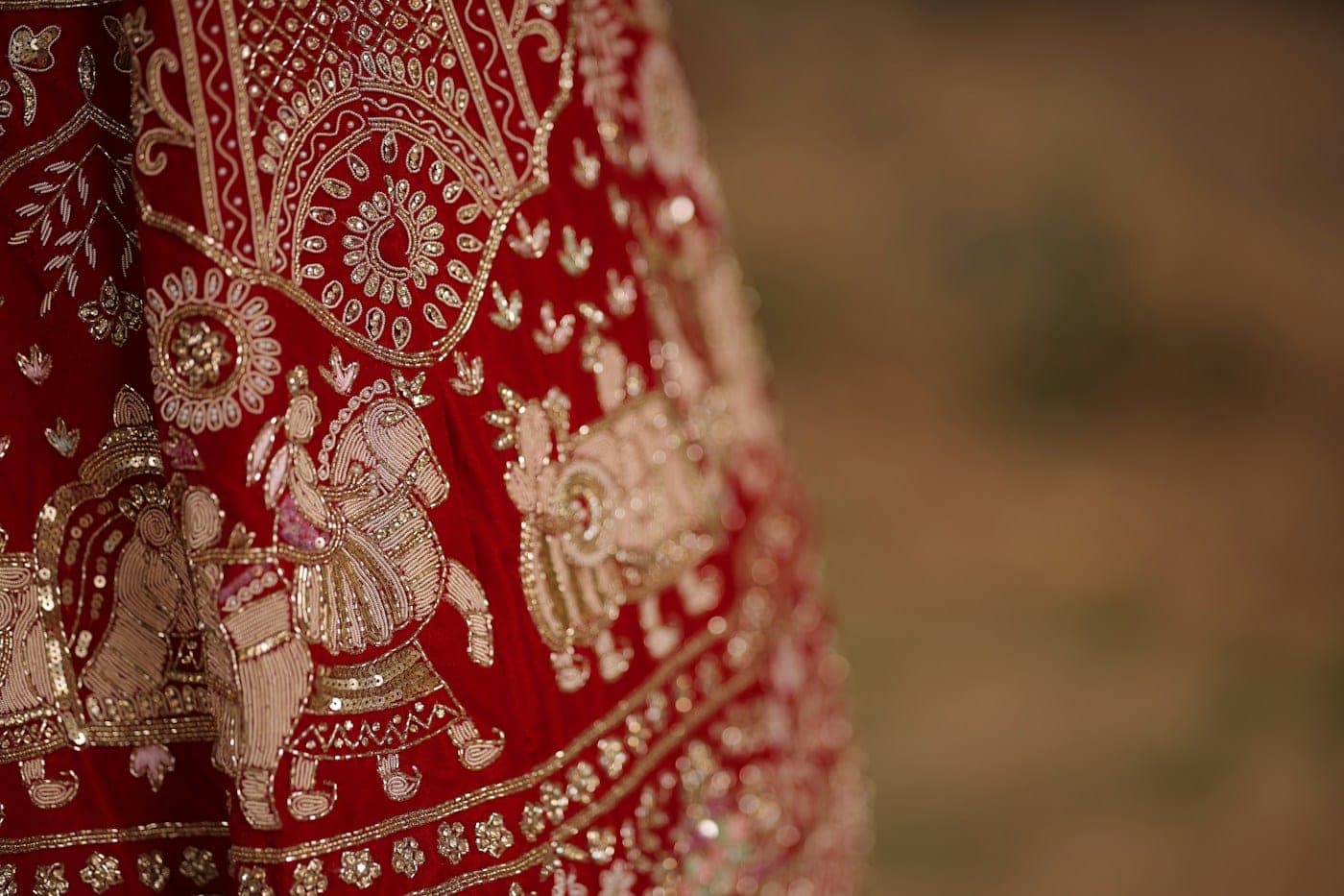 Close-up of gold embroidery on a red lehenga