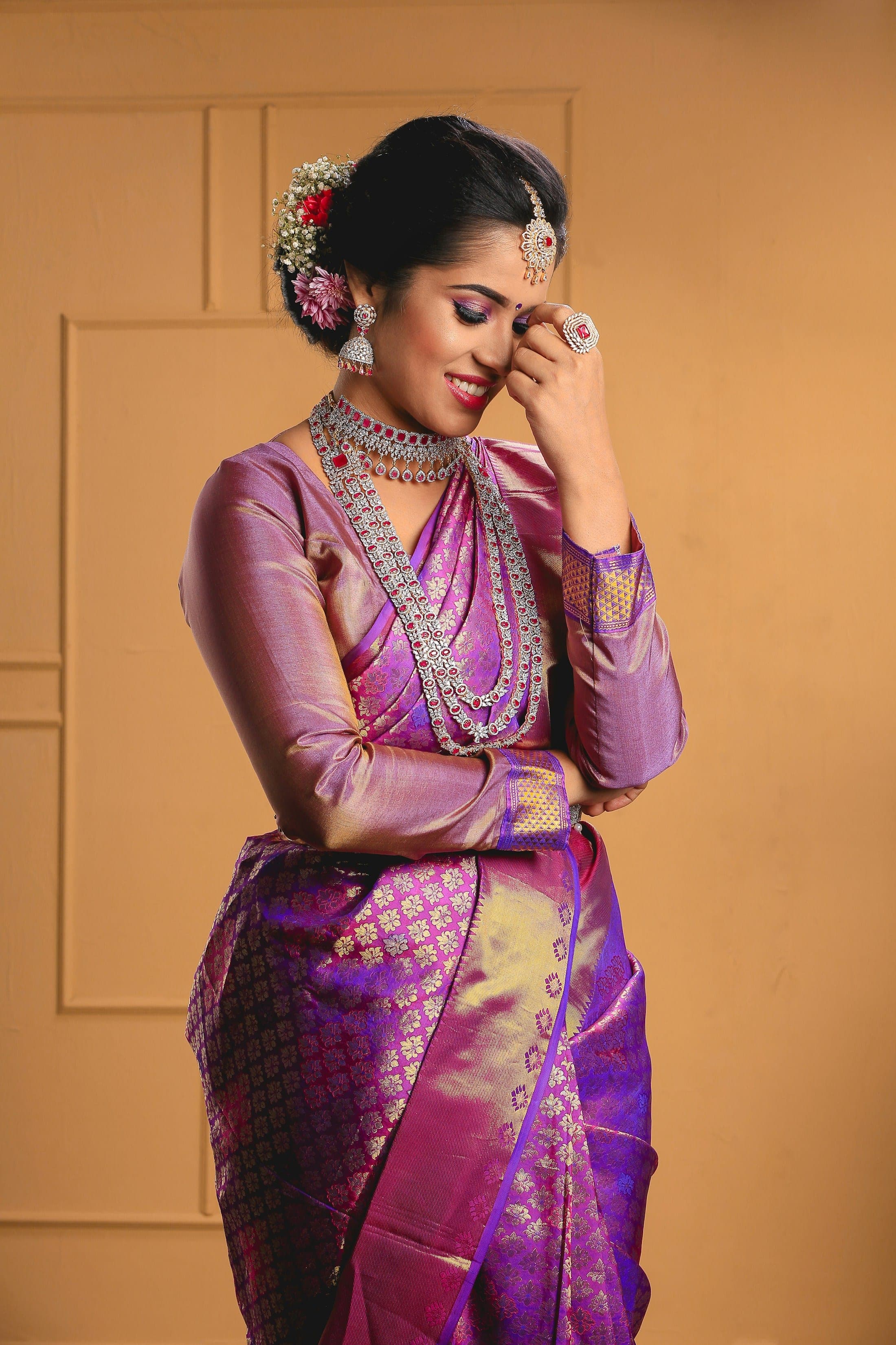 Woman in a purple and gold silk saree with traditional jewellery