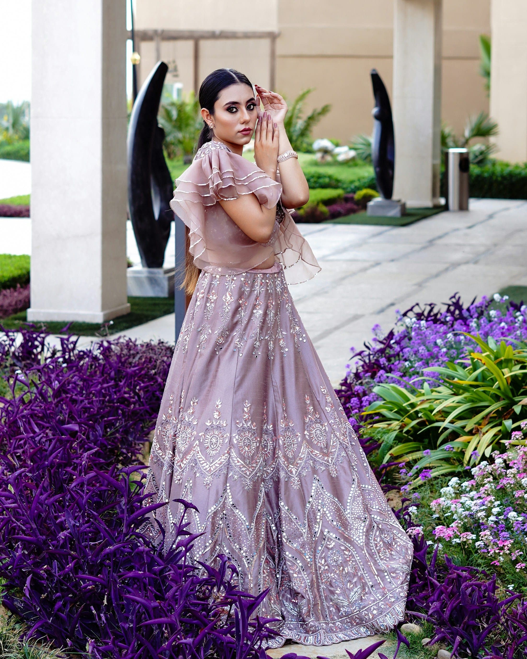 Woman in a lilac embellished lehenga in a modern garden setting
