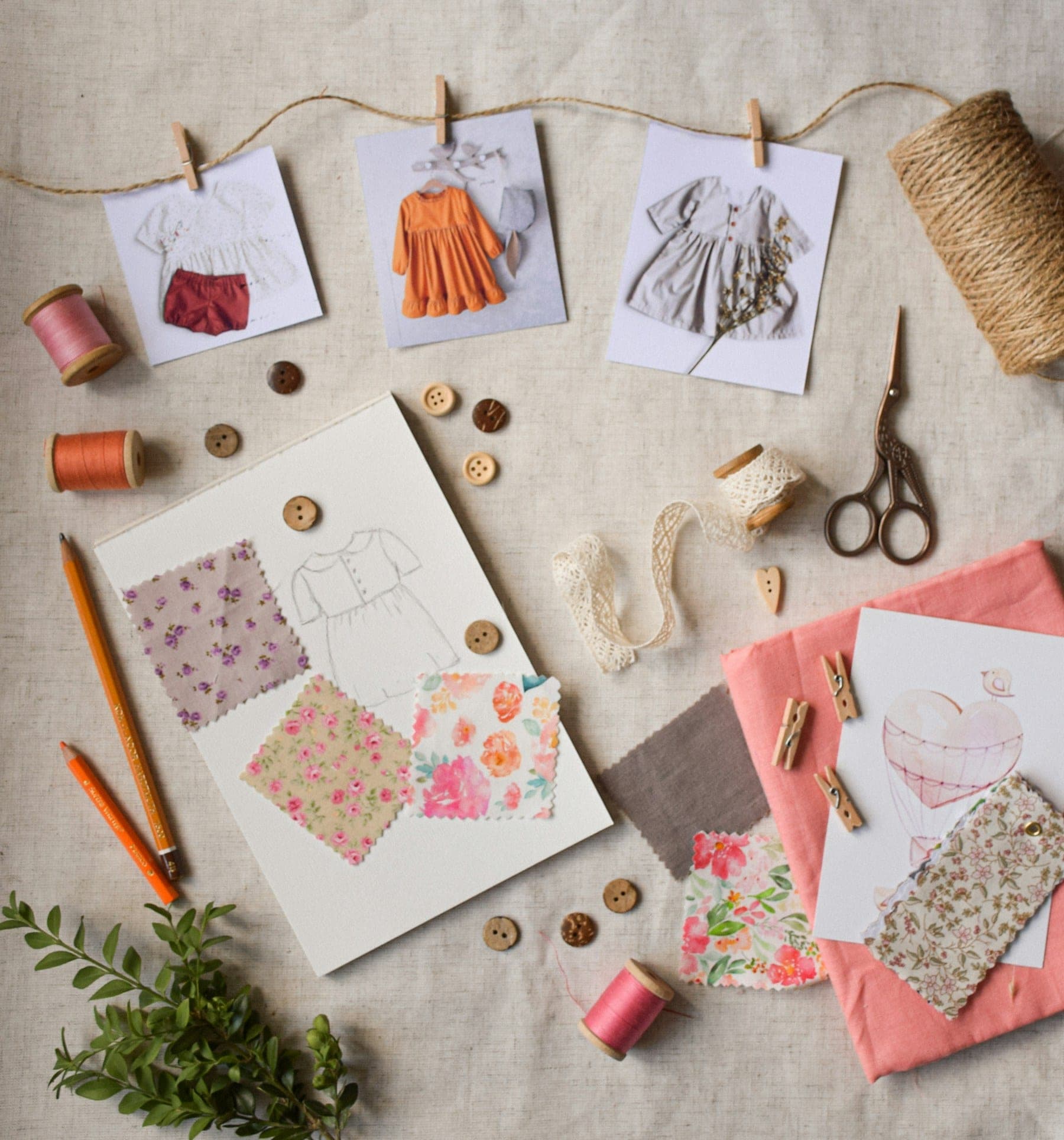 Mood board with fashion sketches, fabric swatches, buttons and thread